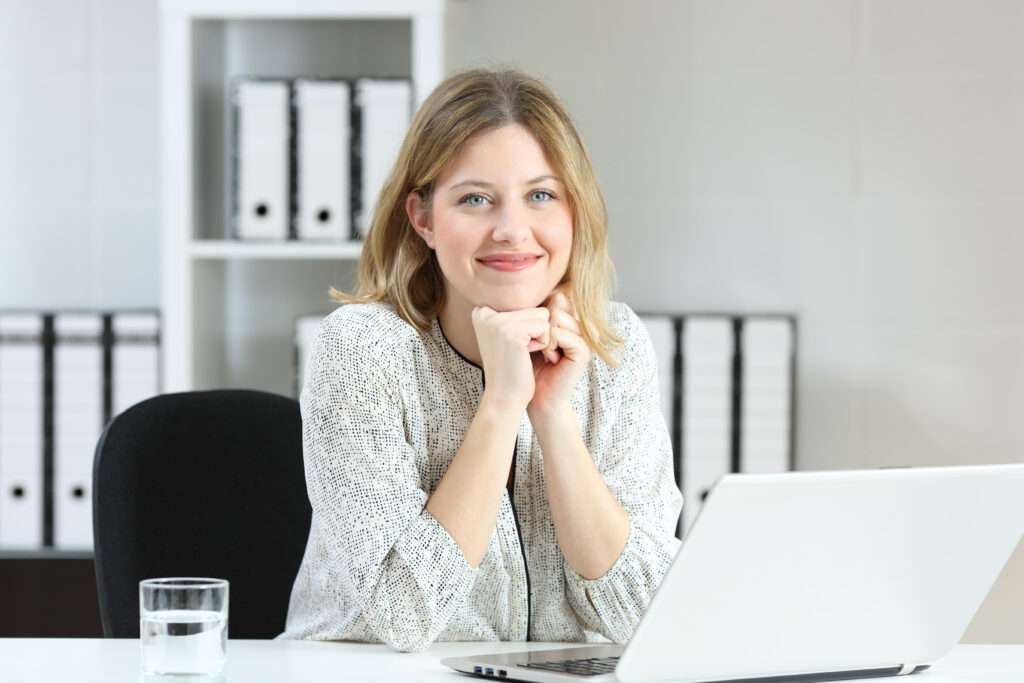 woman sitting in front of computer utilizing patient intake software