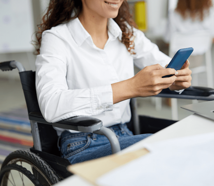 woman in wheelchair using mobile phone to self schedule patient appointment